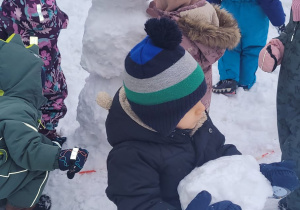 chłopiec trzyma śniegową kulę