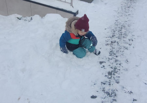 chłopiec siedzi na śniegu