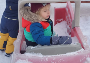 dzieci bawią się w ogrodowym aucie