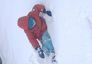 chłopiec leży na śniegu