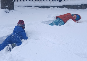 chłopcy leżą na śniegu