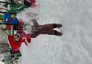 dziewczynka podrzuca śnieg