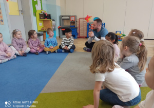 Dzieci siedzą w kole na dywanie