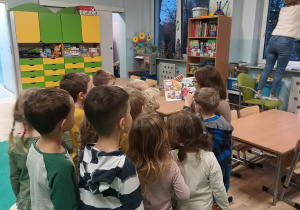 Dzieci uważnie słuchają i oglądają.