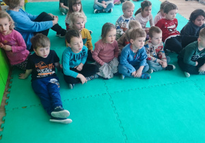 Dzieci siedzą na macie