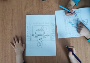 Dzieci kolorują obrazek z robotem