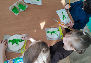 Dinozaury i masa solna - dzieci malują odciski dinozaurów.