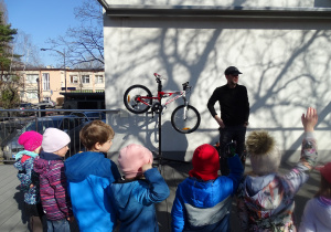 Pan opowiada dzieciom z jakich elementów zbudowany jest rower