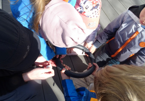 dzieci trzymają dętkę i szukają w niej dziury