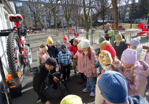 dzieci oglądają zdjęte koło rowerowe