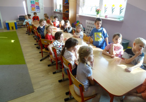 dzieci siedzą przy stole