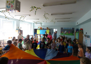 dzieci chodzą z chustą animacyjną w koło