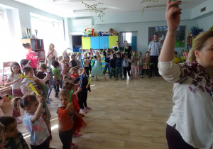 dzieci machają kolorowymi papierowymi miotełkami