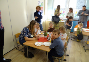 rodzice i dzieci jedzą ciasta w kawiarence