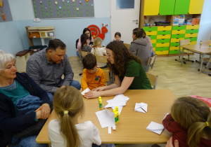 chłopiec składa koszyczek z origami