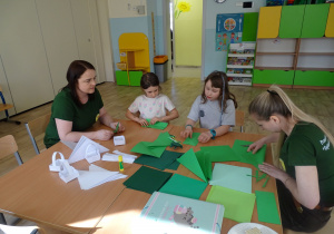 dziewczynki i nauczycielki składają żabki i koszyczki