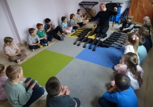 dzieci siedzą i sluchają pana Michała