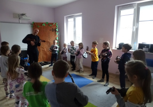dzieci stoją i grają na ukulele