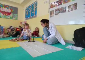 dziewczynka wprawia w ruch wahadło Newtona