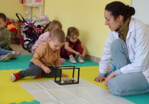 chłopiec wprawia w ruch wahadło Newtona