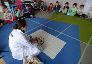 dzieci obserwują wahadło Newtona