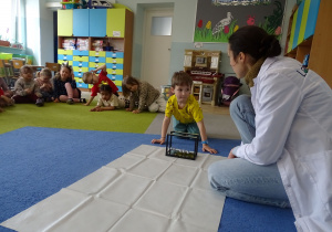 chłopiec wprawia w ruch wahadło Newtona