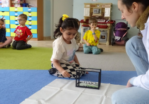 dziewczynka wprawia w ruch wahadło Newtona