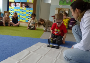 chłopiec wprawia w ruch wahadło Newtona