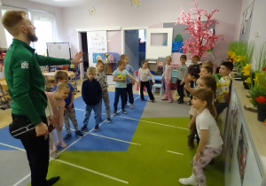 dzieci stoją i słuchają trenera