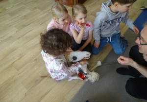 dzieci siedzą i oglądają jawajkę Koziołek Matołek