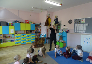 Aktor preznetuje dzieciom jawajkę i kukłę i omawia różnice między lalkami