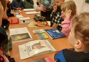 Dzieci oglądają książki napisane alfabetem Braile'a