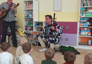 Dzieci słuchają brzmienia chińskich skrzypiec