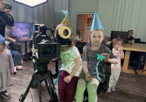Dziewczynki siedzą za kamerą filmową