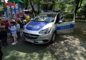dzieci stoją przy radiowozie policyjnym
