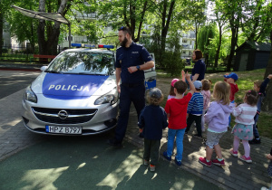 dzieci stoją przy radiowozie policyjnym