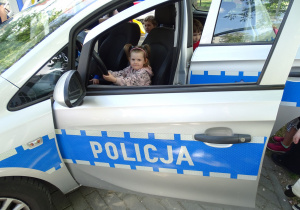 dziewczynka siedzi w policyjnym radiowozie