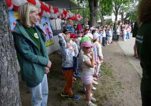 dzieci stoją w ogrodzie przedszkolnym