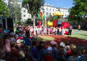 dzieci stoją w ogrodzie przedszkolnym