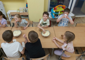 dzieci jedzą popcorn