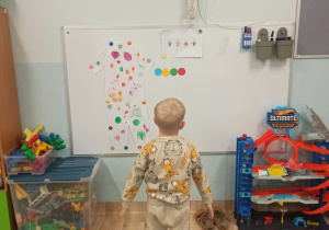 Chłopiec stoi przed tablicą