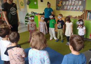 Dzieci stoją na dywanie w kole