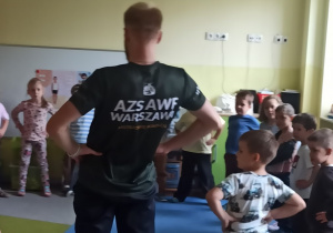 Dzieci wykonują rozgrzewkę z trenerem