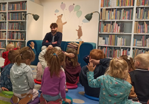 Dzieci rozmawiają z panem w bibliotece