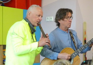 Dwóch panów gra na instrumentach