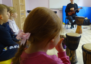 Dzieci obserwują pana grającego na ukulele
