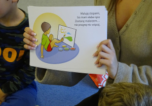 Dzieci oglądają książkę o różnych niepełnosprawnościach