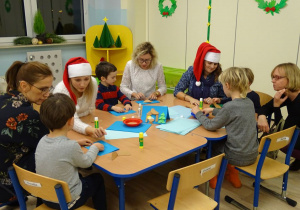 Dzieci wykonują kartkę świąteczną