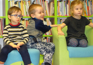 Dzieci siedzą i słuchają książki